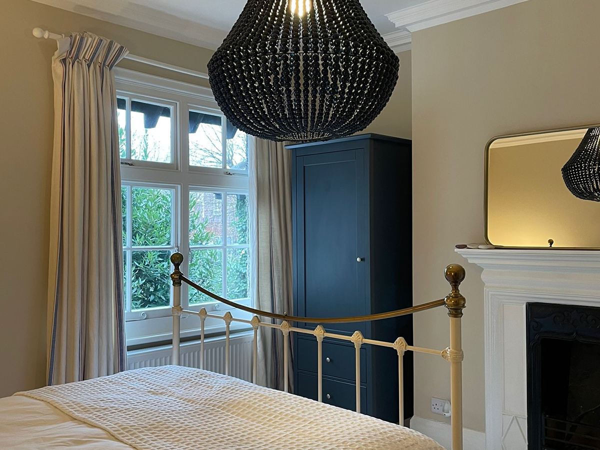 Interior shot of Reside Living bedroom with Reside Navy William Chandelier above bed