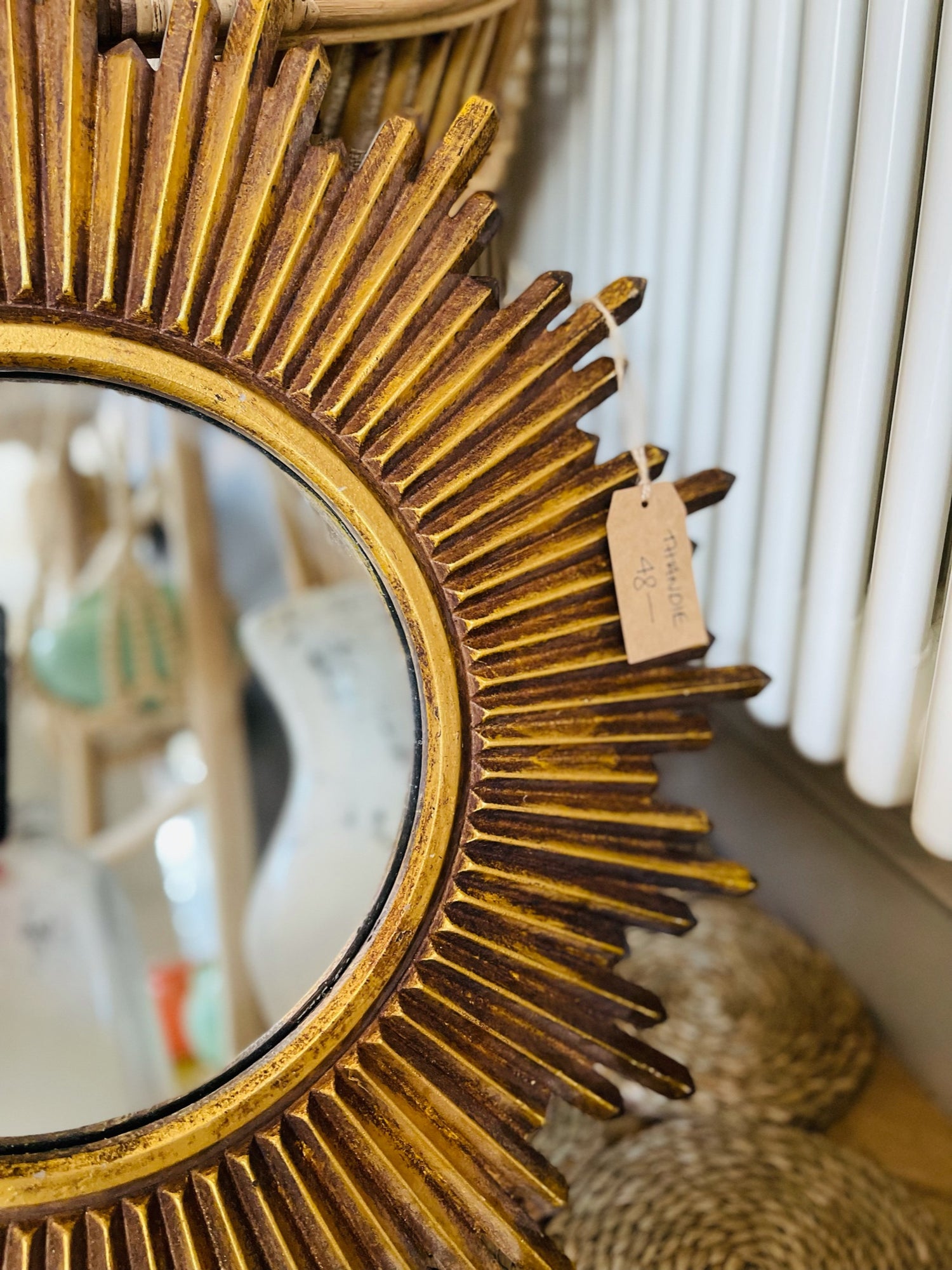 Close up of restoring Reside Living Thandie metallic gold sunburst mirror