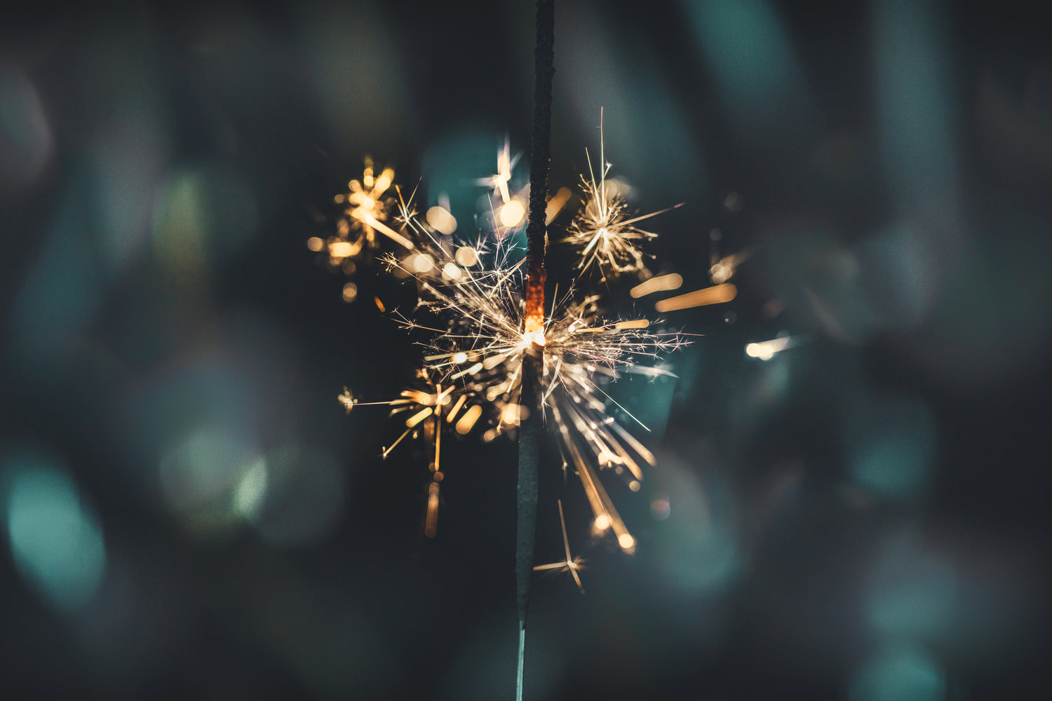 Close up of lit sparkler with bokeh