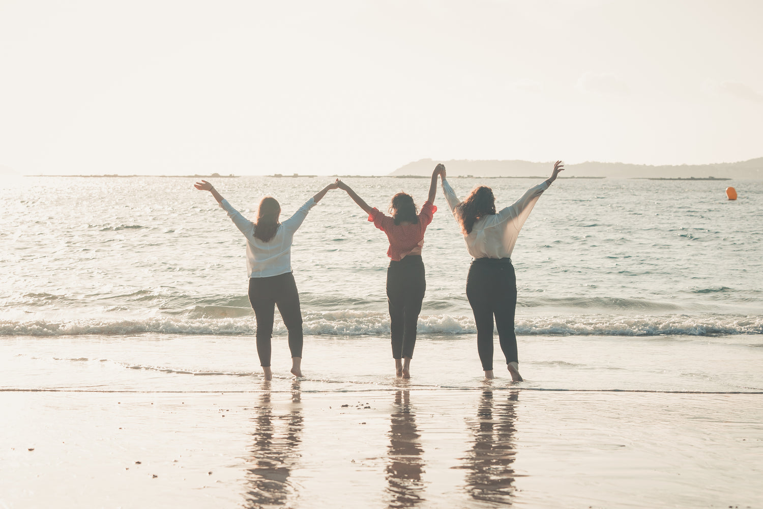 Background image of Our Trinity Reside Living page showing three women together on a beach